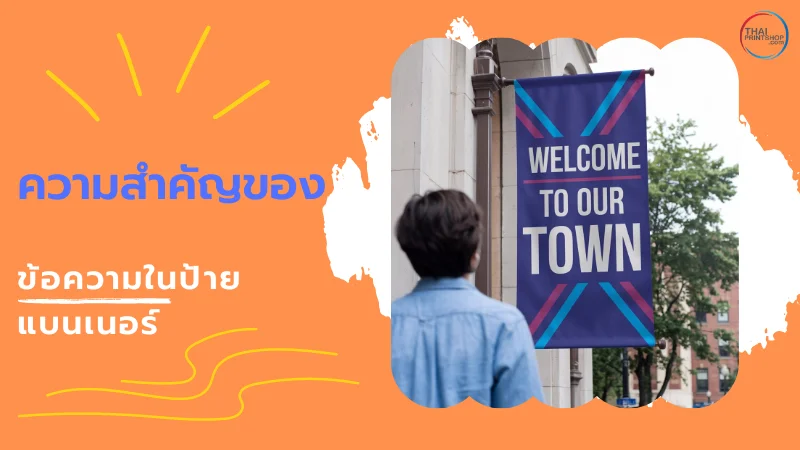 ผู้ชายยืนมองแบนเนอร์สีม่วงเข้มที่มีข้อความ 'Welcome to Our Town' ติดอยู่บนเสาหน้าตึก พร้อมข้อความ 'ความสำคัญของข้อความในป้ายแบนเนอร์'